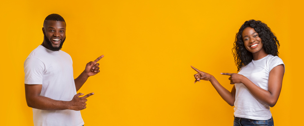 Lovely black couple pointing at copy space